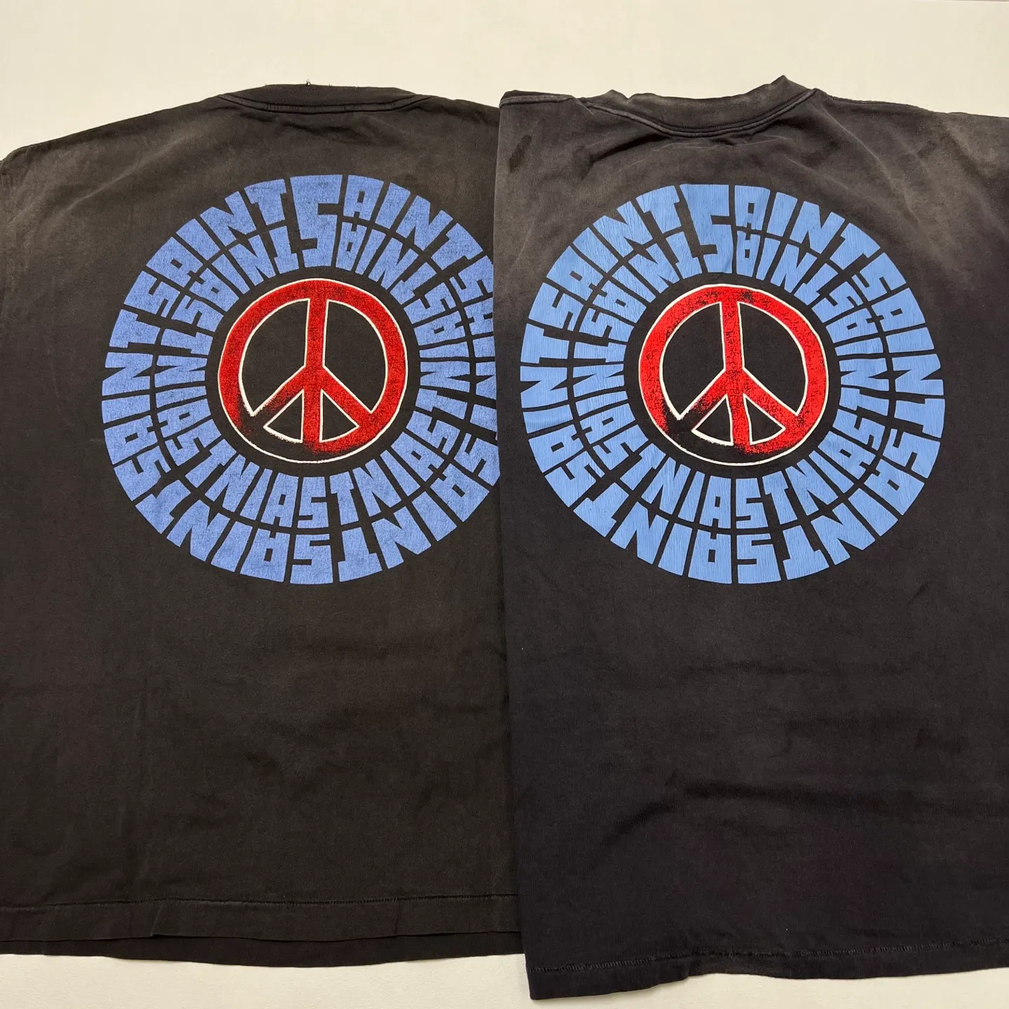 SAINT Mxxxxxx IDEOLOGICAL SS TEE/BLK Peace and anti-war crack pattern tee, washed black S-XL, look for the cylindrical fabric without side seams, the open width is almost meaningless Asut ready-made garments dyed, the whole piece is sprayed with horse-hair spray, and then sprayed again to fade, the collar and cuffs are frayed, many places are broken, oversized printing position, genuine level restoration, complete accessories, with little angel anti-counterfeiting label